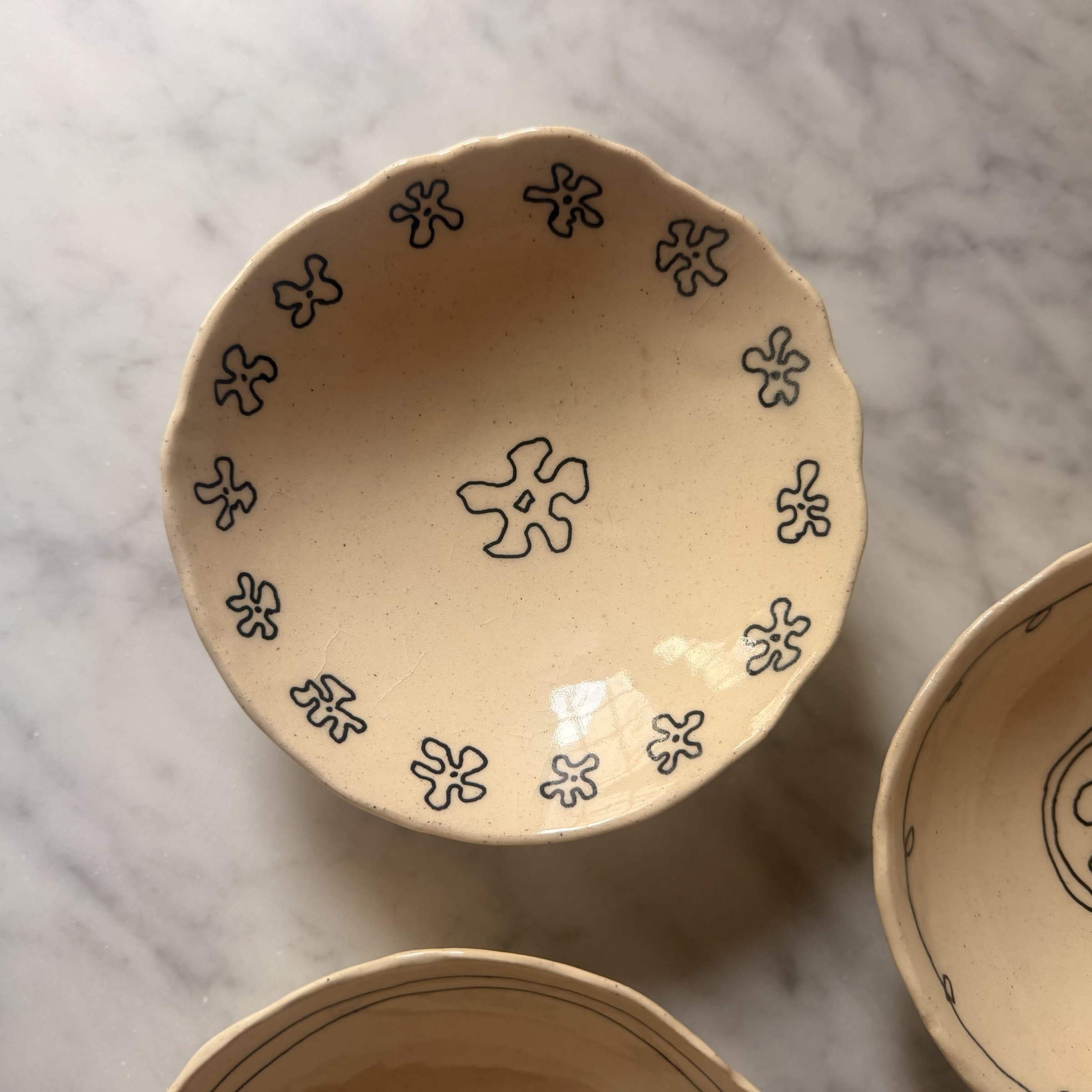 A single scalloped bowl with a ring of flower motifs around the rim and a big flower in the middle.